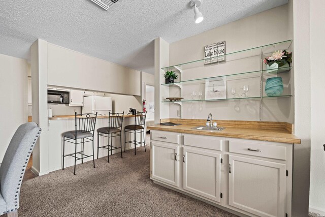 5371 Central Ave Unit 6H, Hot Springs, AR 71913 - indoor wet bar with freestanding refrigerator, black microwave, carpet, and a textured ceiling