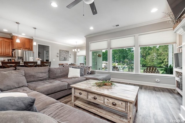 living area featuring baseboards, ornamental molding, wood finished floors, and recessed lighting