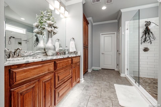 bathroom with double vanity, ornamental molding, a tile shower, a sink, and baseboards