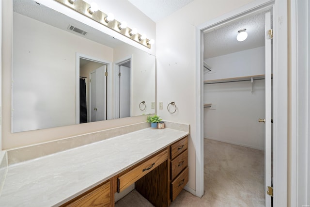 711 S Red St, Sheridan, AR 72150 - full bath featuring a walk in closet, vanity, a textured ceiling, and visible vents