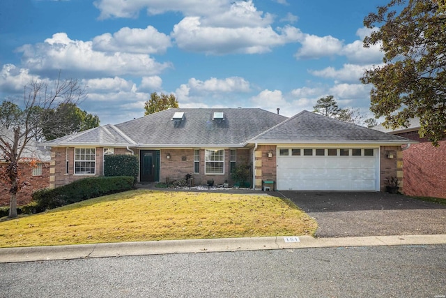 view of front of property with driveway, a front lawn, roof with shingles, and an attached garage