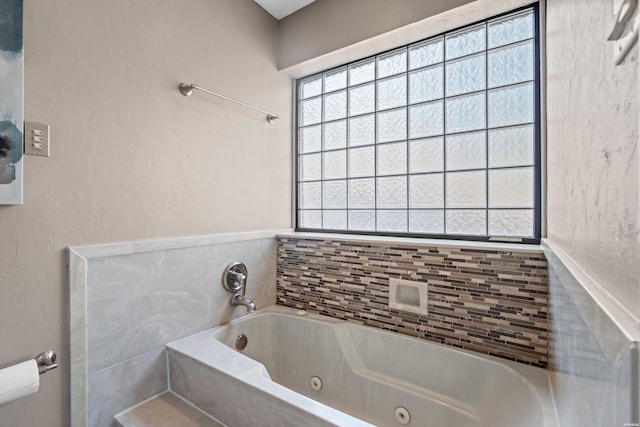 bathroom featuring a tub with jets and a wealth of natural light