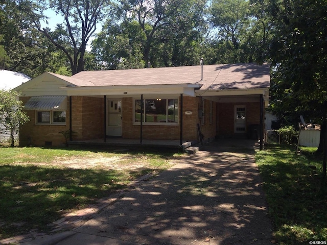 single story home featuring a carport, crawl space, brick siding, and driveway