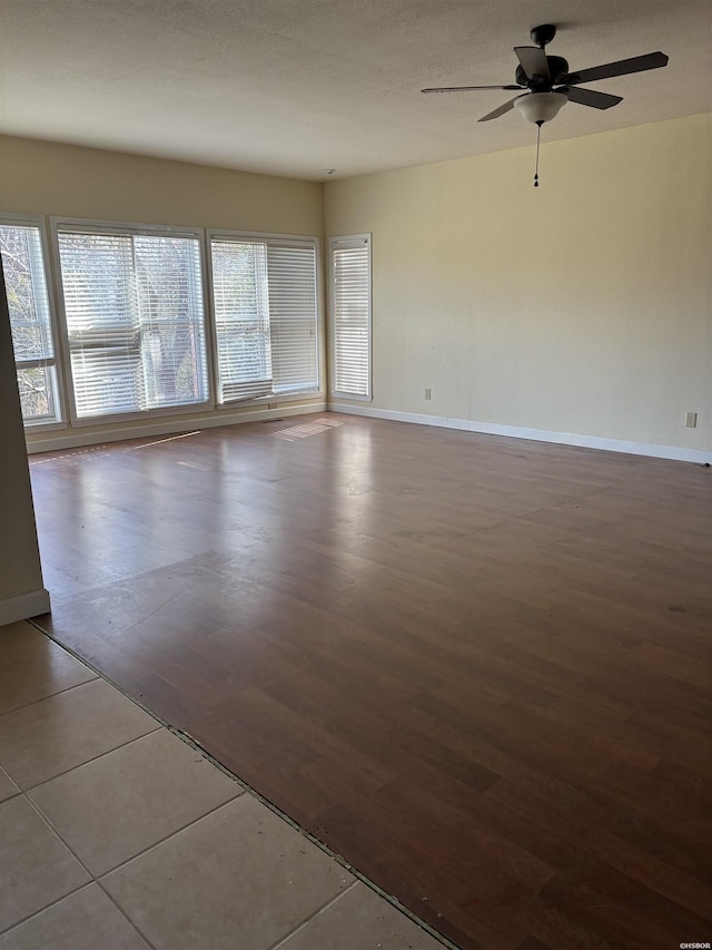 spare room featuring a ceiling fan, baseboards, and wood finished floors