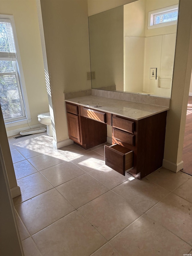 bathroom with vanity, baseboards, and tile patterned floors