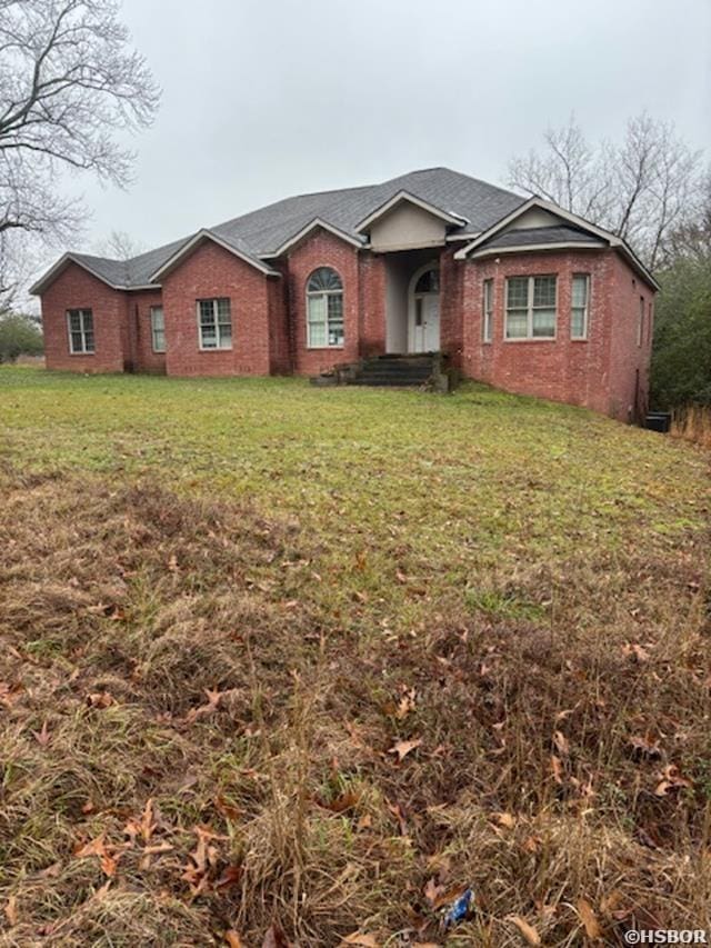 single story home with brick siding and a front yard