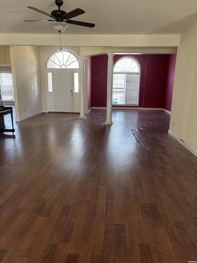 foyer entrance with plenty of natural light, decorative columns, baseboards, and dark wood-style flooring