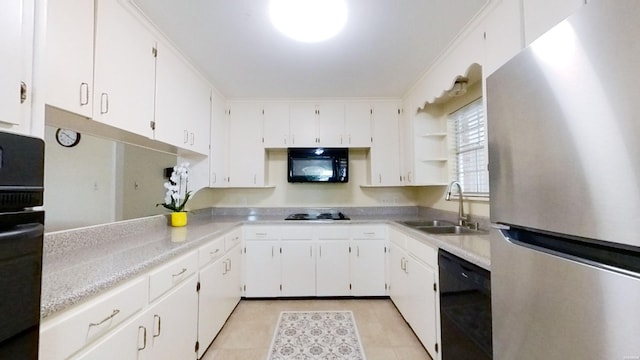 kitchen with black appliances, white cabinetry, light countertops, and a sink