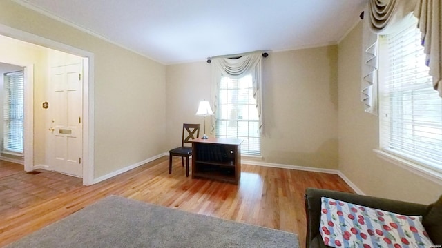 sitting room with ornamental molding, baseboards, and wood finished floors