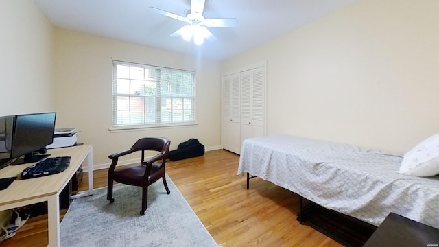 bedroom featuring a closet, ceiling fan, baseboards, and wood finished floors