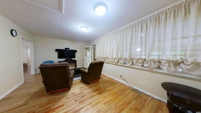 living area featuring visible vents, baseboards, and wood finished floors