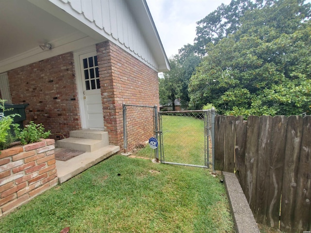 view of yard featuring entry steps, a gate, and fence