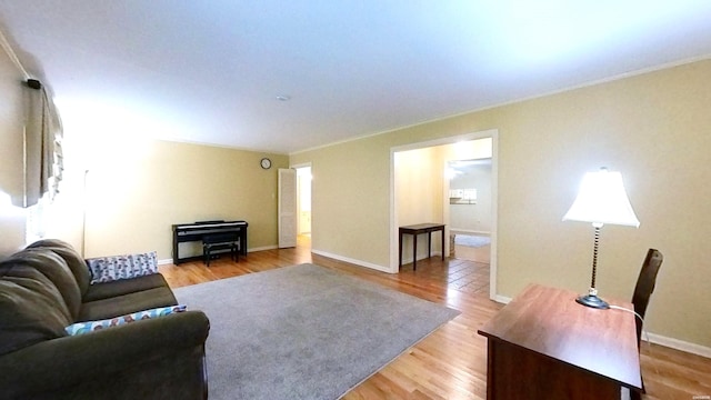 living area with light wood-style floors, crown molding, and baseboards