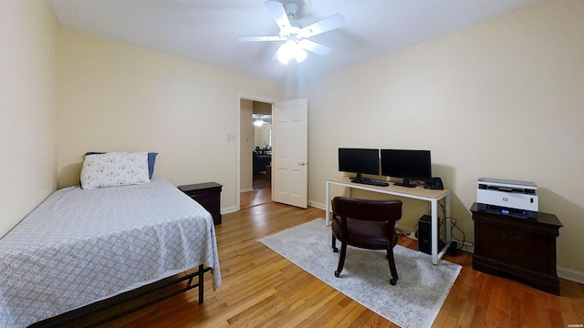 bedroom with ceiling fan, wood finished floors, and baseboards