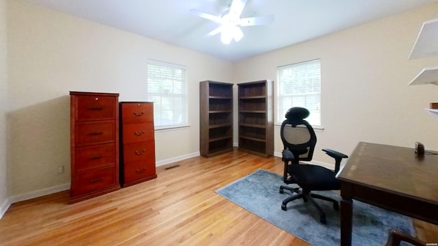 office area with light wood-type flooring, baseboards, and a ceiling fan