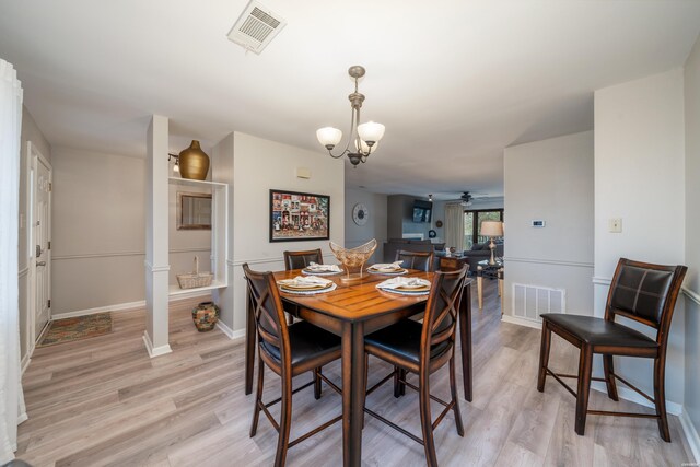 dining room featuring baseboards, visible vents, and light wood finished floors