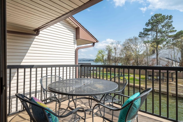 balcony featuring outdoor dining area and a water view