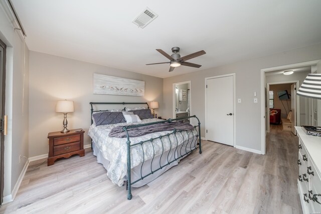 bedroom featuring light wood finished floors, visible vents, and baseboards