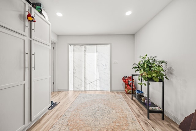 interior space with baseboards, light wood-type flooring, and recessed lighting