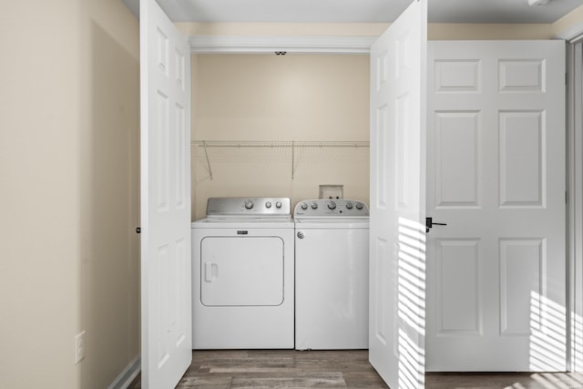 washroom with laundry area, wood finished floors, and independent washer and dryer