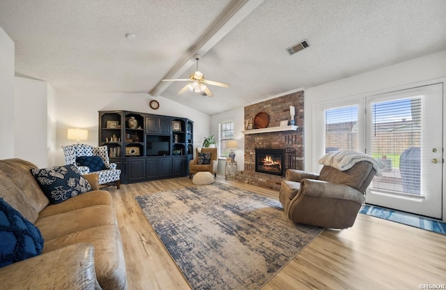 200 Cole Pl, Hot Springs, AR 71901 - living room with light wood-style floors, a textured ceiling, ceiling fan, and a brick fireplace
