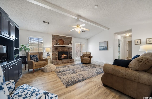 200 Cole Pl, Hot Springs, AR 71901 - living room with light wood-style floors, a textured ceiling, a brick fireplace, and a ceiling fan