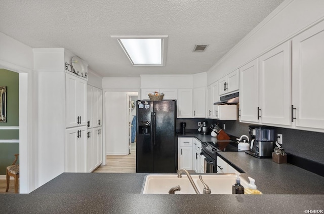 200 Cole Pl, Hot Springs, AR 71901 - kitchen with black appliances, under cabinet range hood, dark countertops, white cabinets, and a textured ceiling