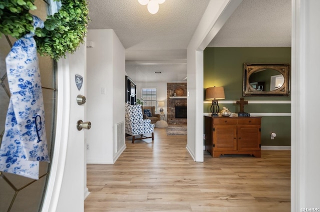 200 Cole Pl, Hot Springs, AR 71901 - foyer with light wood-style floors, a stone fireplace, and a textured ceiling