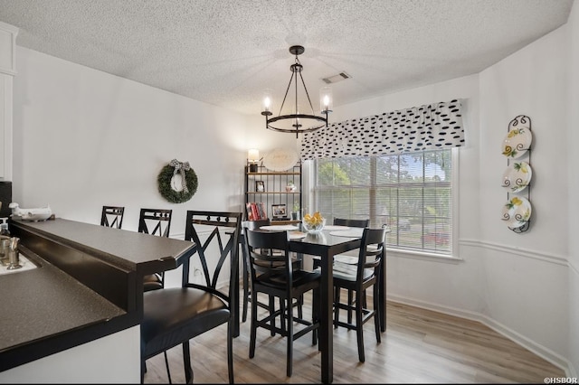 200 Cole Pl, Hot Springs, AR 71901 - dining room with a chandelier, light wood-style floors, and a textured ceiling