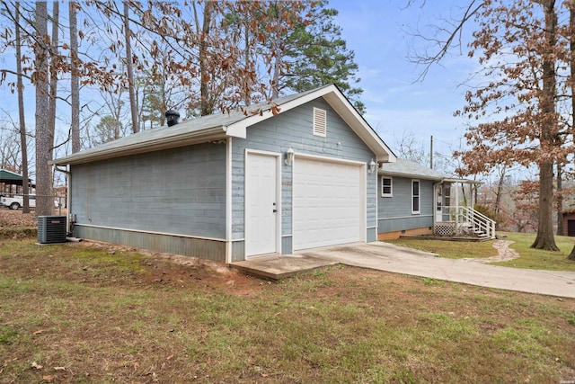 view of side of property featuring concrete driveway, a yard, and central AC unit