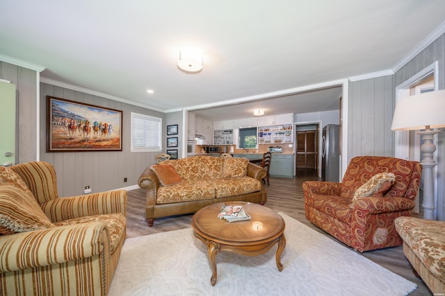 living room featuring crown molding, wood finished floors, and baseboards