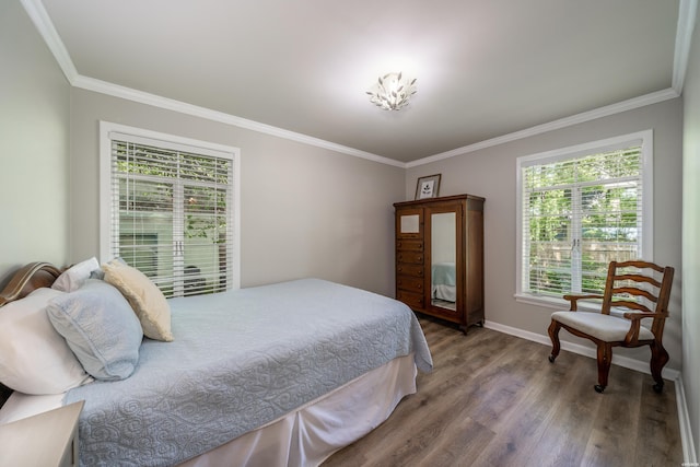 bedroom with baseboards, wood finished floors, and crown molding