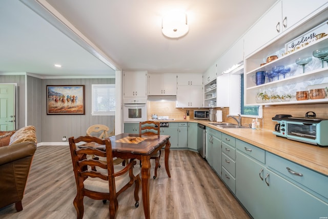 kitchen featuring a sink, open shelves, ornamental molding, a toaster, and appliances with stainless steel finishes