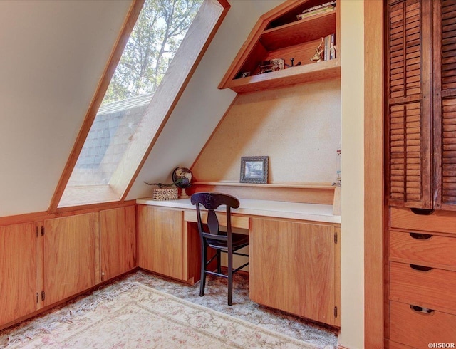 office featuring lofted ceiling, a wainscoted wall, wood walls, and built in study area