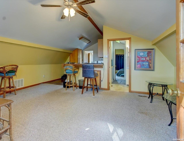 interior space featuring baseboards, visible vents, light colored carpet, lofted ceiling with beams, and a breakfast bar area