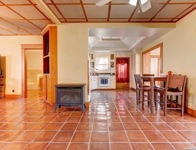 dining room with tile patterned flooring, a wood stove, and baseboards