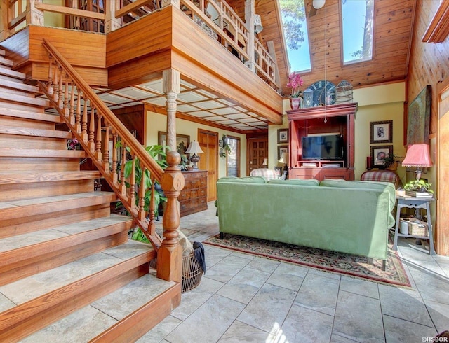 living room with stairway, a high ceiling, and light tile patterned floors