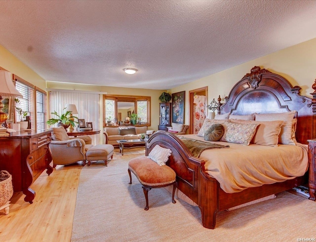 bedroom with a textured ceiling and light wood finished floors