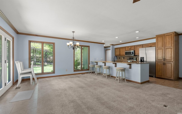 5 Arga Pl, Hot Springs, AR 71909 - kitchen with appliances with stainless steel finishes, ornamental molding, brown cabinets, a breakfast bar, and light stone countertops