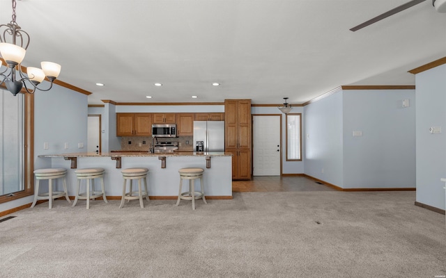 5 Arga Pl, Hot Springs, AR 71909 - kitchen featuring appliances with stainless steel finishes, a ceiling fan, crown molding, brown cabinetry, and a peninsula