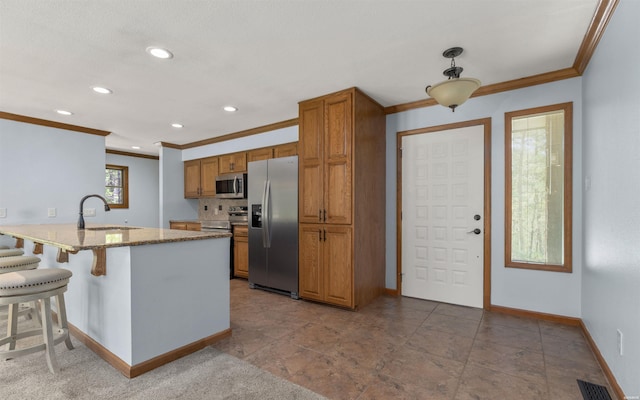 5 Arga Pl, Hot Springs, AR 71909 - kitchen featuring stainless steel appliances, ornamental molding, brown cabinets, a peninsula, and a breakfast bar area