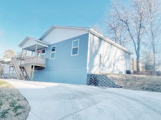 view of home's exterior featuring stairs and concrete driveway