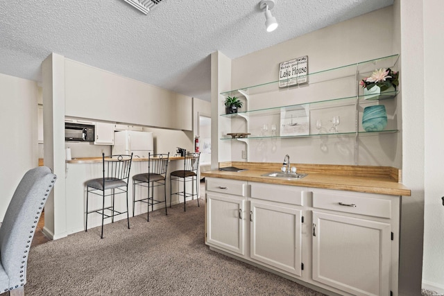 5371 Central Ave Unit 6E, Hot Springs, AR 71913 - indoor wet bar with freestanding refrigerator, black microwave, carpet, and a textured ceiling