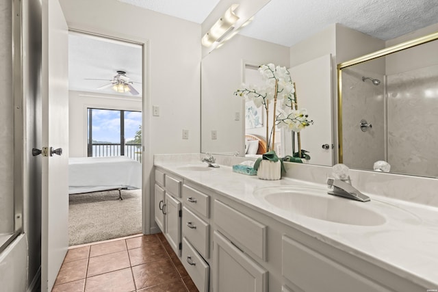 5371 Central Ave Unit 6E, Hot Springs, AR 71913 - ensuite bathroom featuring double vanity, an enclosed shower, a textured ceiling, ceiling fan, and tile patterned flooring