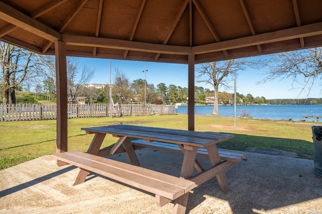 view of patio / terrace featuring a gazebo, a water view, and fence