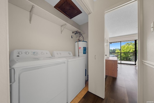 washroom with dark wood-type flooring, laundry area, water heater, and washer and clothes dryer