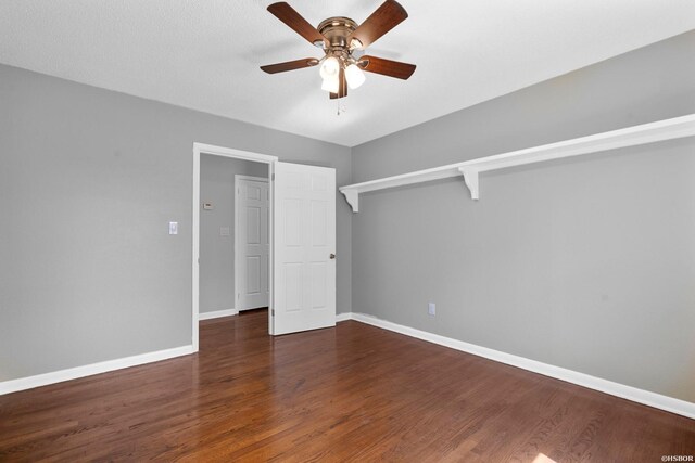 unfurnished bedroom featuring dark wood-style floors, a ceiling fan, and baseboards