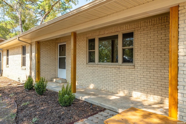 entrance to property featuring brick siding