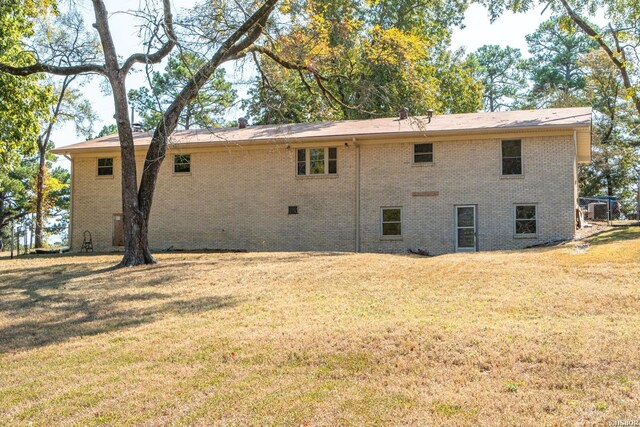 rear view of property with a yard and brick siding