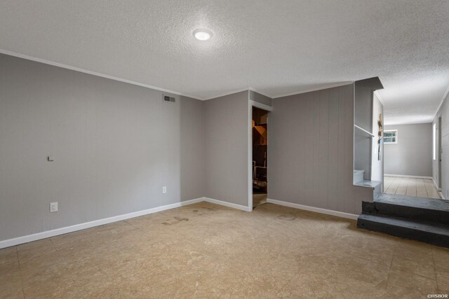 unfurnished living room featuring visible vents, ornamental molding, a textured ceiling, baseboards, and stairs